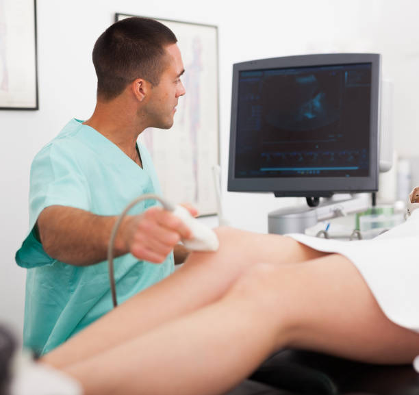 istock Man sonographer examining female patient 1164978123