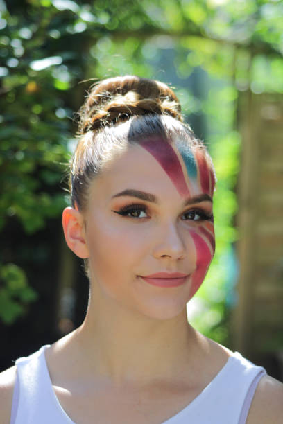 istock Beautiful young woman with a make-up shaped multicolored sun. 1164980686