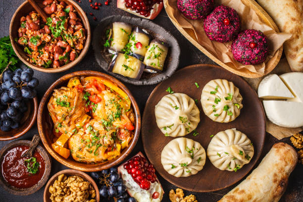 fundo georgian tradicional da culinária. khinkali, phali, chahokhbili, lobio, queijo, rolos de berinjela, fundo escuro. - traditional foods - fotografias e filmes do acervo