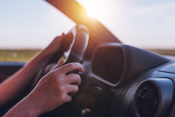 istock Driving car through countryside, female hands on steering wheel 1164983449