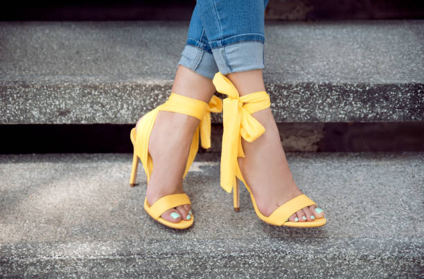 mujer con tacones amarillos - dress shoe fotografías e imágenes de stock