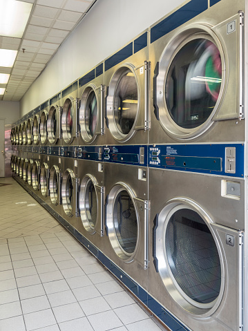 A row of washing machines in public laundry.