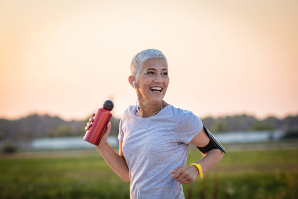 femme aînée de sports - headphones relaxation outdoors caucasian photos et images de collection