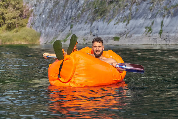 istock Young man is swimming on air sofa. 1165001646