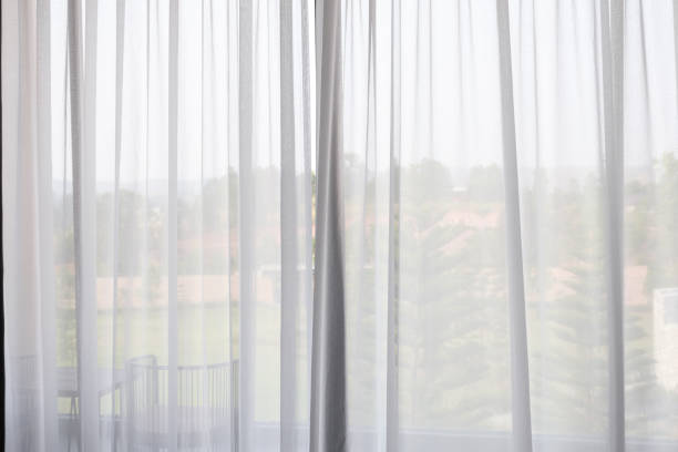 istock window curtain with green garden abstract blur background 1165005932