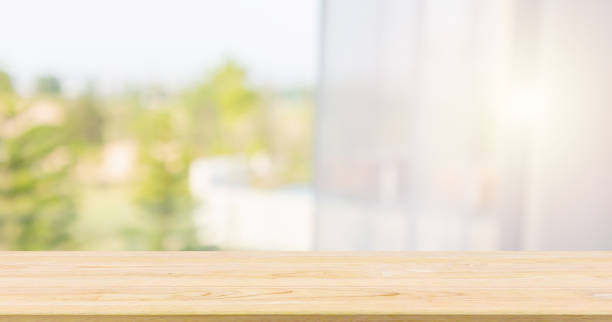 istock Empty wood table top with window curtain abstract blur background for product display 1165005933