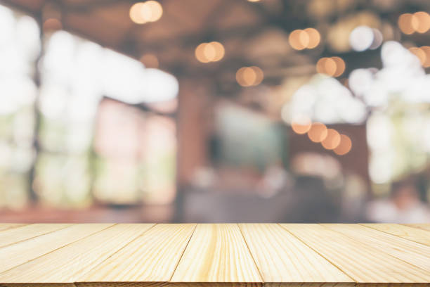 istock Empty wooden table top with cafe restaurant or coffee shop window interior abstract blur defocused with bokeh light background for montage product display 1165006016