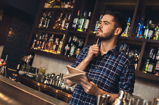 Bartender Notebook Bartender Muda Berdiri Di Bar Counter Memegang Pemikiran Notebook Foto ...