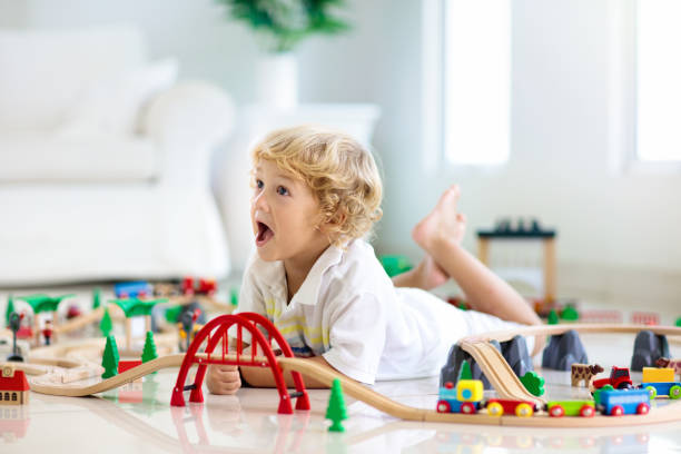 istock Kids play wooden railway. Child with toy train. 1165010201