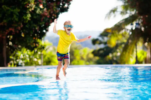 Photo of Child in swimming pool. Summer vacation with kids.