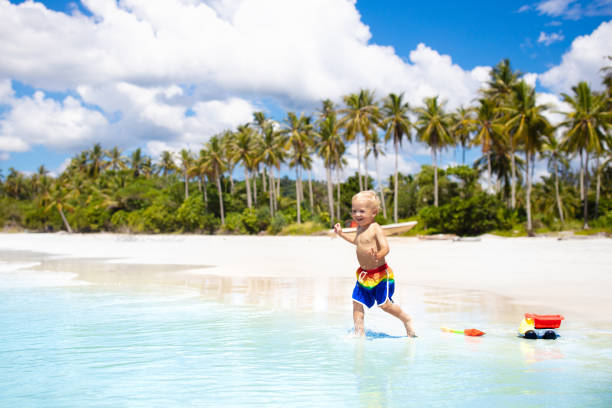 Kids play on tropical beach. Sand and water toy. Child playing on tropical beach with palm trees. Little baby boy at sea shore. Family summer vacation. Kids play with water and sand toys. Ocean and island fun. Travel with young children in Asia. 18797 stock pictures, royalty-free photos & images