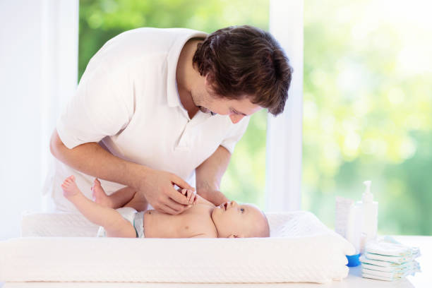 father changing diaper to baby boy. dad and child. - starting at the bottom imagens e fotografias de stock