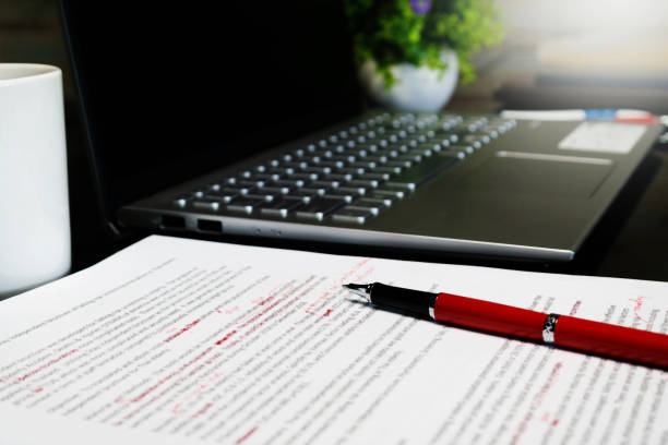 proofreading blur proofreading sheet on table with red pen and laptop proof reading documents stock pictures, royalty-free photos & images