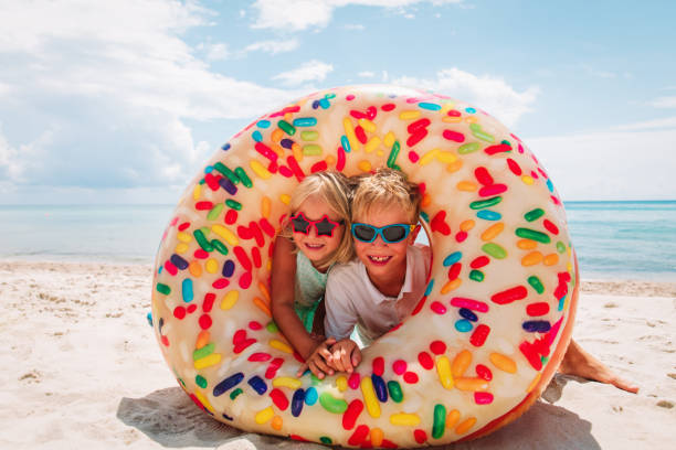 istock happy cute boy and girl play with floaties on beach 1165019820