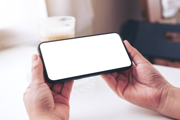 istock a woman holding black mobile phone with blank desktop screen 1165023228