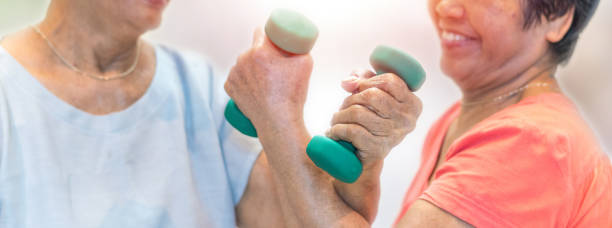 istock Strong and healthy senior old people holding  dumbbells for doing exercise or physical therapy in nursing home. 1165023362