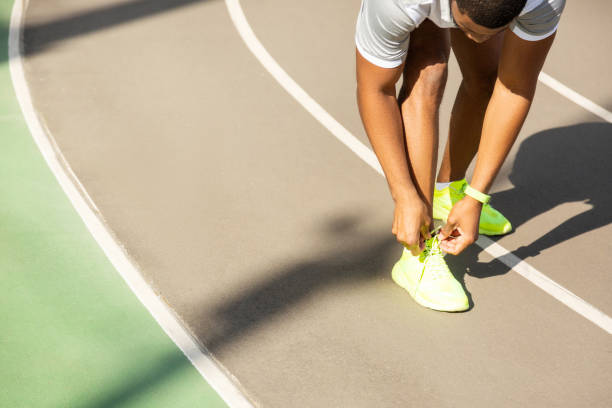 istock Young male athlete tying laces at the stadium 1165026771