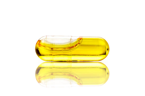 Gold colored pills on white background. Horizontal composition with copy space.