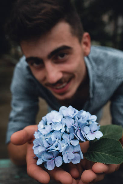 istock Attractive man is holding flowers 1165031544