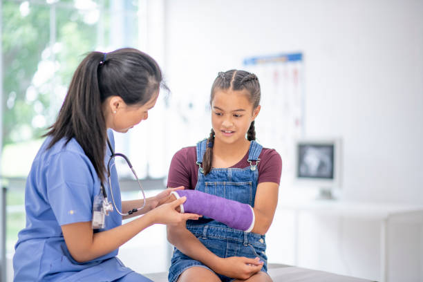Hispanic girl at medical appointment with a broken arm Beautiful young girl goes to a medical check up for her broken bone. orthopedic cast stock pictures, royalty-free photos & images