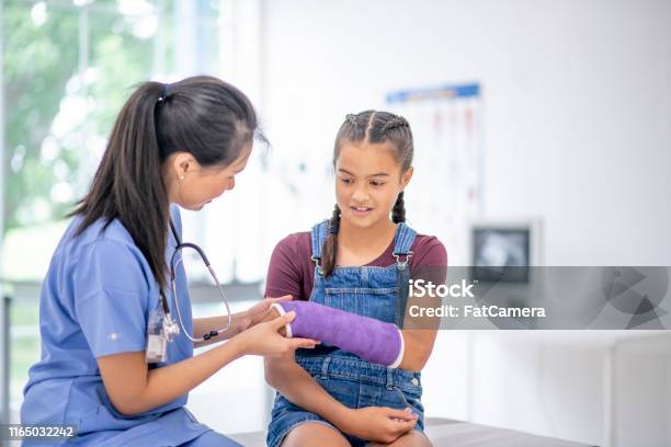 Hispanic Girl At Medical Appointment With A Broken Arm Stock Photo - Download Image Now