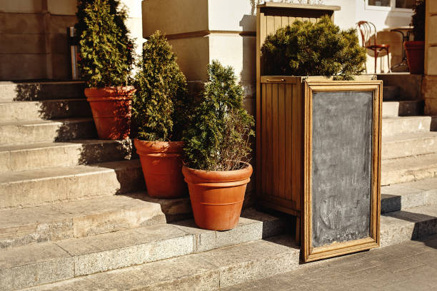 istock empty black chalk board in classical frame for advertising or menu, space for text in city street 1165036680