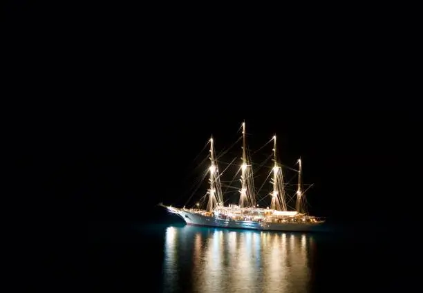 Closeup of an Illuminated sailing boat on the sea by night