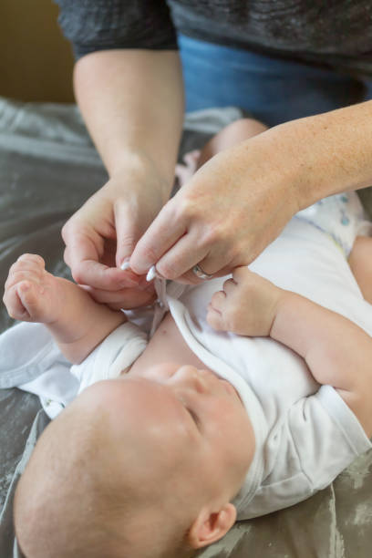 istock Woman dressing up little baby 1165037487
