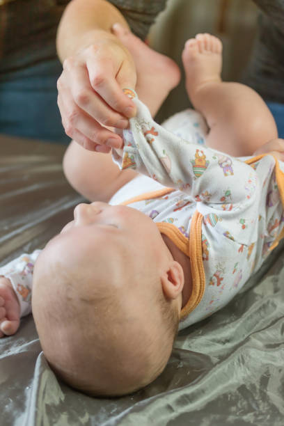 istock Woman dressing up little baby's sleeve 1165037491