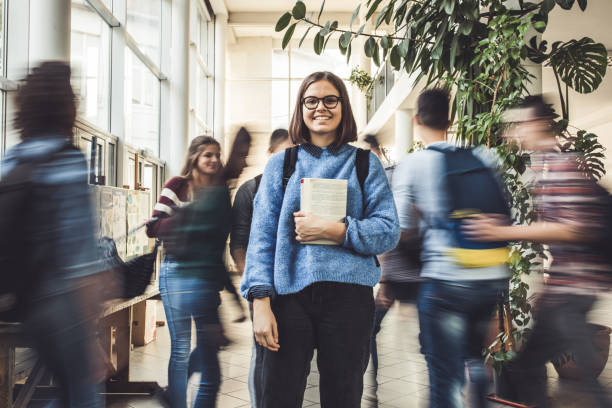 istock Happy teenage student among her classmate in blurred motion. 1165038553