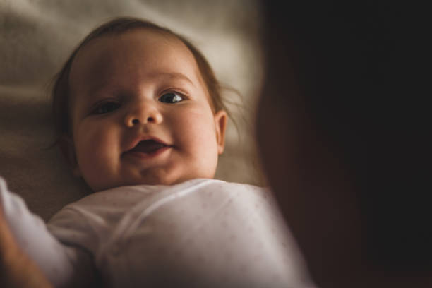 istock Cheerful newborn baby smiling and looking at camera 1165042234