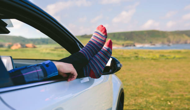 istock Unrecognizable man resting feet up sitting on the car 1165044315
