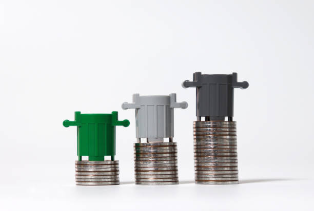 istock Three miniature trash cans and piles of coins. 1165045611