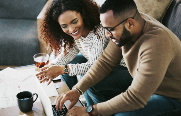 pagare le bollette è facile quando lo fai online - home finances couple computer african ethnicity foto e immagini stock