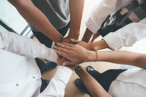 istock Young people putting their hands together showing unity and teamwork. 1165046730