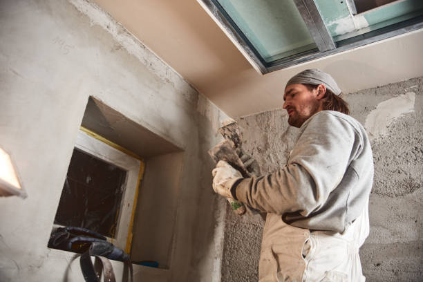 istock Construction worker plastering gypsum walls inside the house. 1165050742