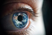 Macro photo of the woman's eye and Earth planet