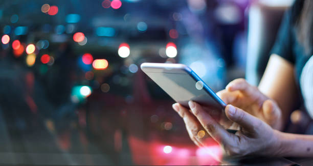 mujer usando el teléfono inteligente móvil en la luz de la noche colorido fondo - teléfono móvil fotografías e imágenes de stock