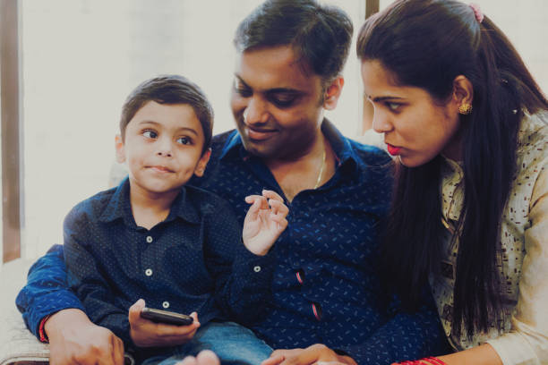 istock Kid Busy Playing on the smartphone while parents are trying to have a conversation 1165052182