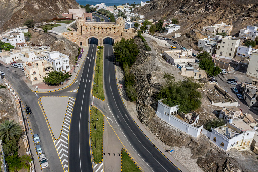 Al Bahri road passing below the Muscat Gate in Old Muscat, Oman. Taken from air.