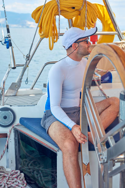istock Sailor using wheel to steer rudder on a sailing boat. 1165053230