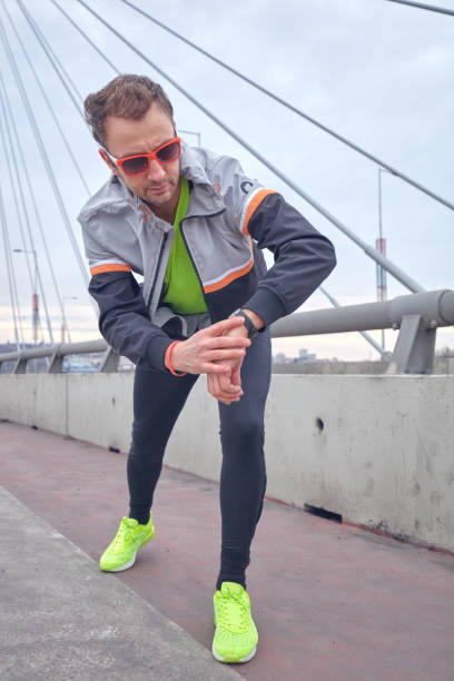 istock Sportsman working out / jogging on a big city urban bridge. 1165053607