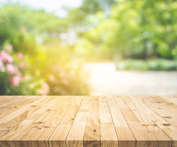 istock Empty wood table top on blur abstract green from garden and home area background 1165053703