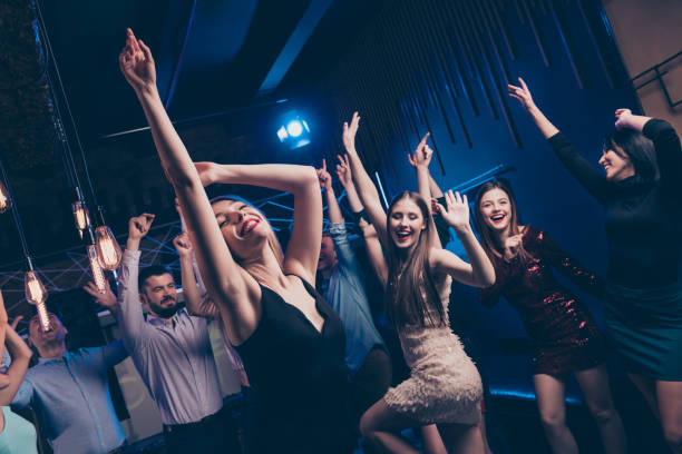 istock Nice-looking gorgeous attractive glamorous slim fit graceful cheerful cheery glad positive stylish girl and guys having fun festal social lifestyle in modern popular fashionable luxury place nightclub 1165053940