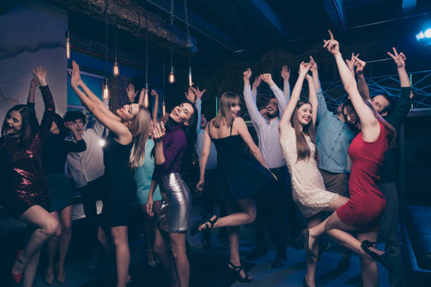 istock Nice-looking gorgeous attractive glamorous slim fit thin graceful cheerful positive stylish girls and guys having fun festive festal social life lifestyle in fashionable luxury place nightclub indoors 1165054867