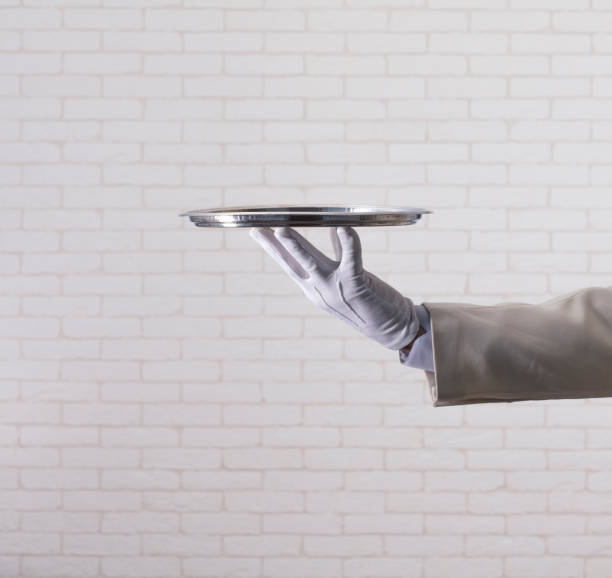 istock waiter in a white glove  holding  a silver tray 1165057566