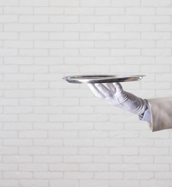 istock waiter in a white glove  holding  a silver tray 1165059383