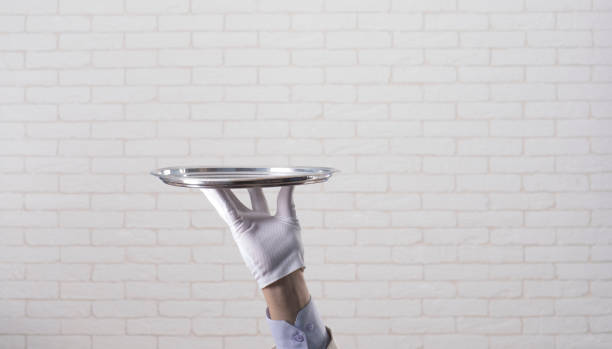 istock waiter in a white glove  holding  a silver tray 1165060424