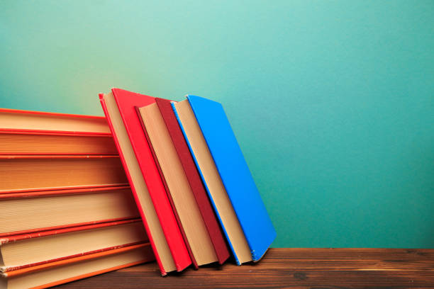 istock pile of old books panorma, good copy space  on blue background - Image 1165060686