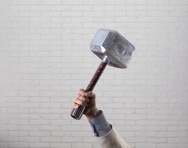businessman's hand holds hammer Thor